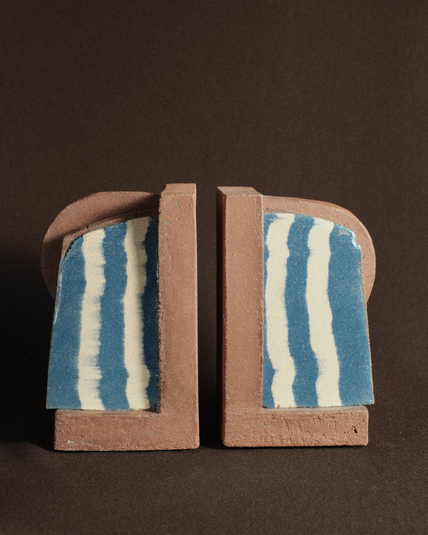 Pair of Shane Gabier ceramic bookends in pigmented clay with banded inlay, shown as two sculptural forms.
