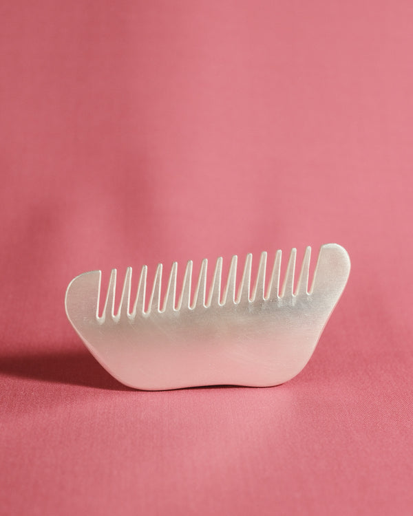 Christian+Jade Comb carved from silver-plated metal and polished stainless steel, comfortable in hand with refined tactility.