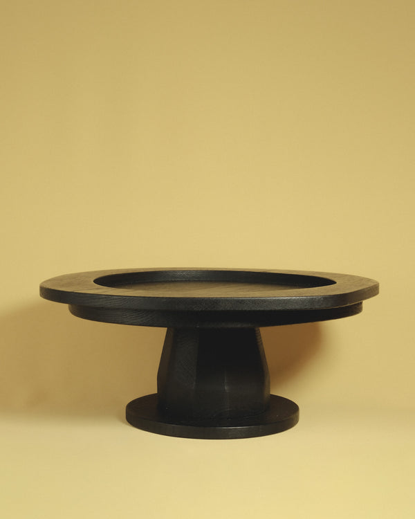 Christian+Jade Pedestal carved from oxidised oak with sharp geometry and darkened surface elevating and balancing the table.