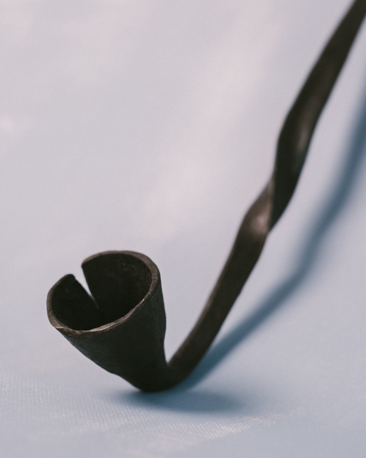 Bell of Campanula Snuffer by Agnieszka Owsiany, hand-forged metal with sculptural restraint