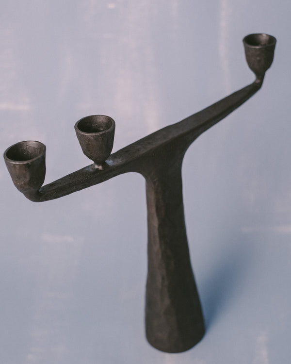 Forged steel candle holder by Agnieszka Owsiany, curved twin arms, angled view
