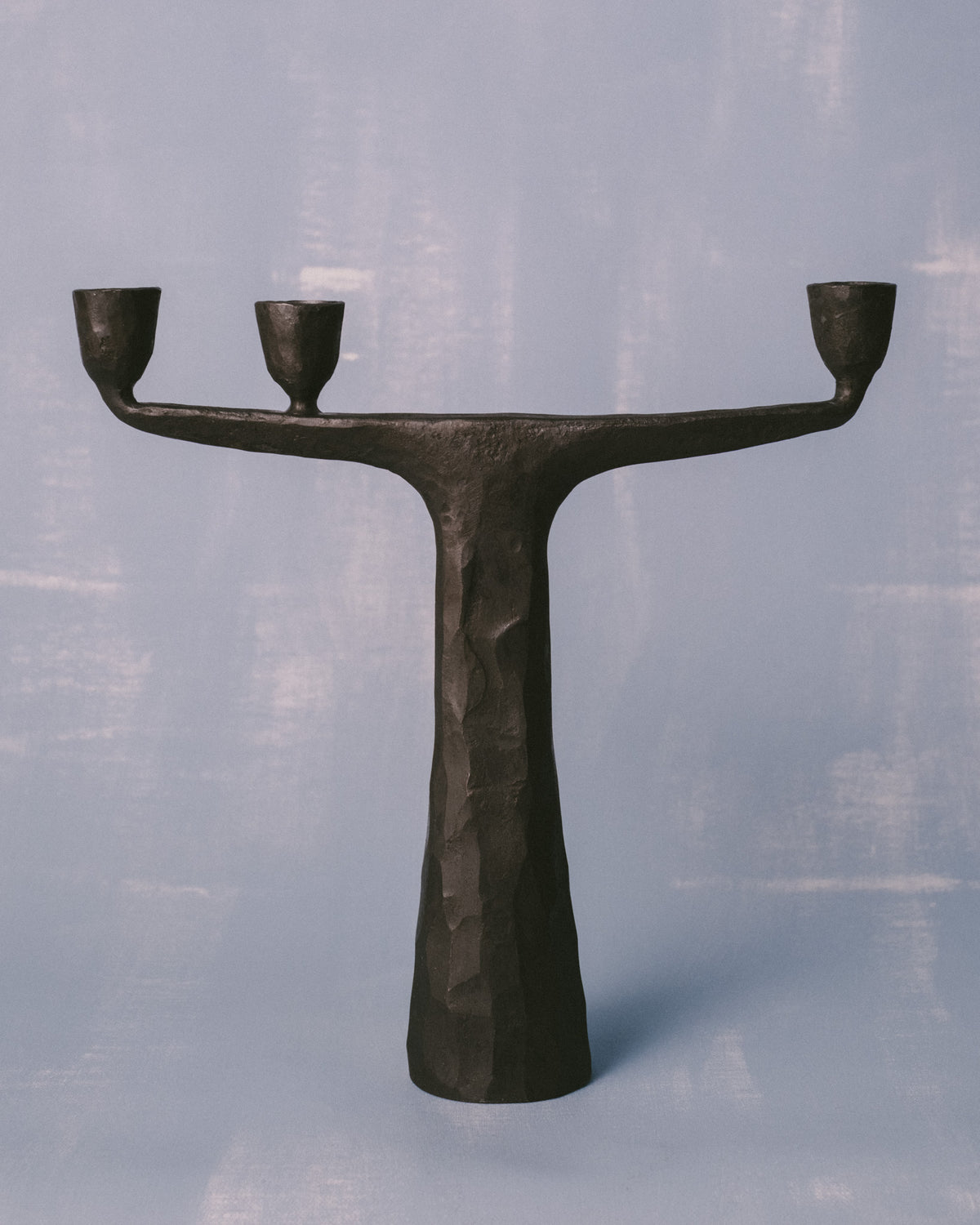 Candle Holder Medium III by Agnieszka Owsiany, forged steel with two curved arms, front view