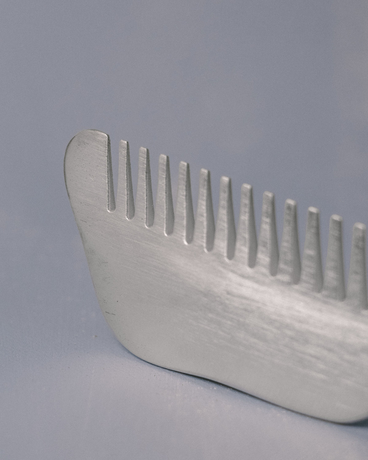 Alternate profile of Christian+Jade Comb in silver-plated metal, sculptural balance for the hand
