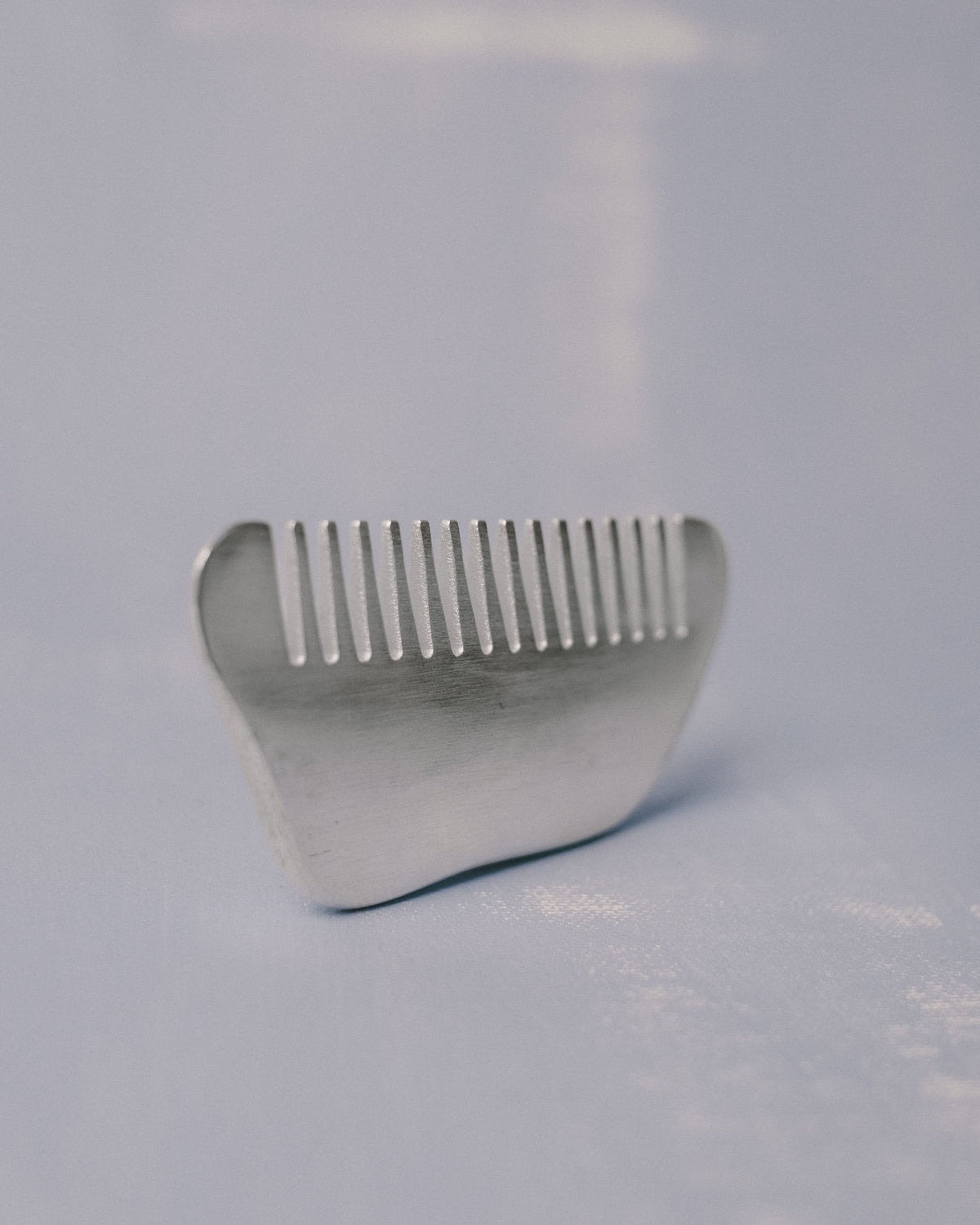 Silver-plated Comb by Christian+Jade, angled view highlighting sculptural weight and teeth