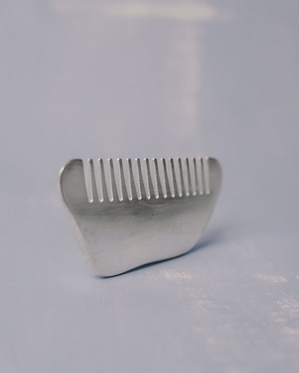 Silver-plated Comb by Christian+Jade, angled view highlighting sculptural weight and teeth