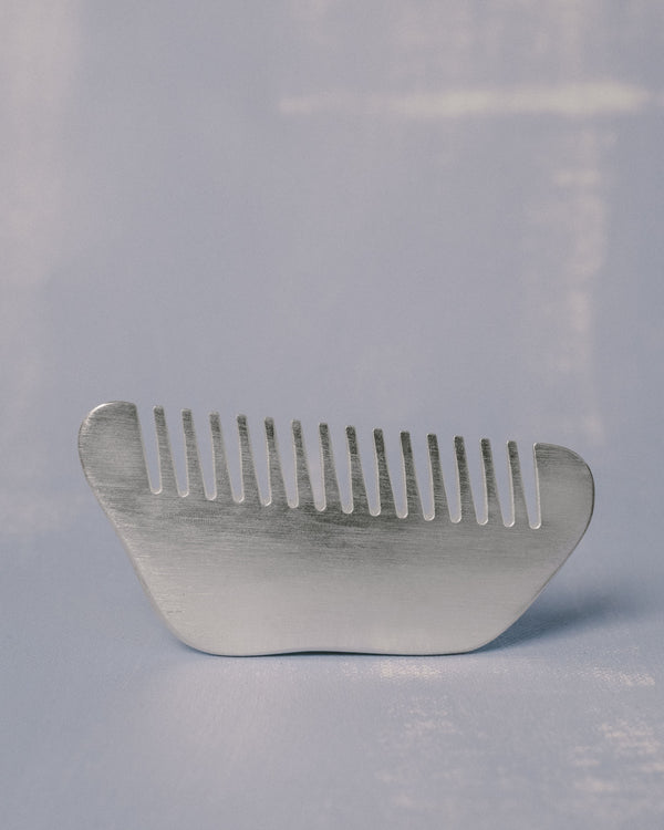 Christian+Jade Comb, shaped from silver-plated metal, side profile showing polished surface and comfortable hand-held form