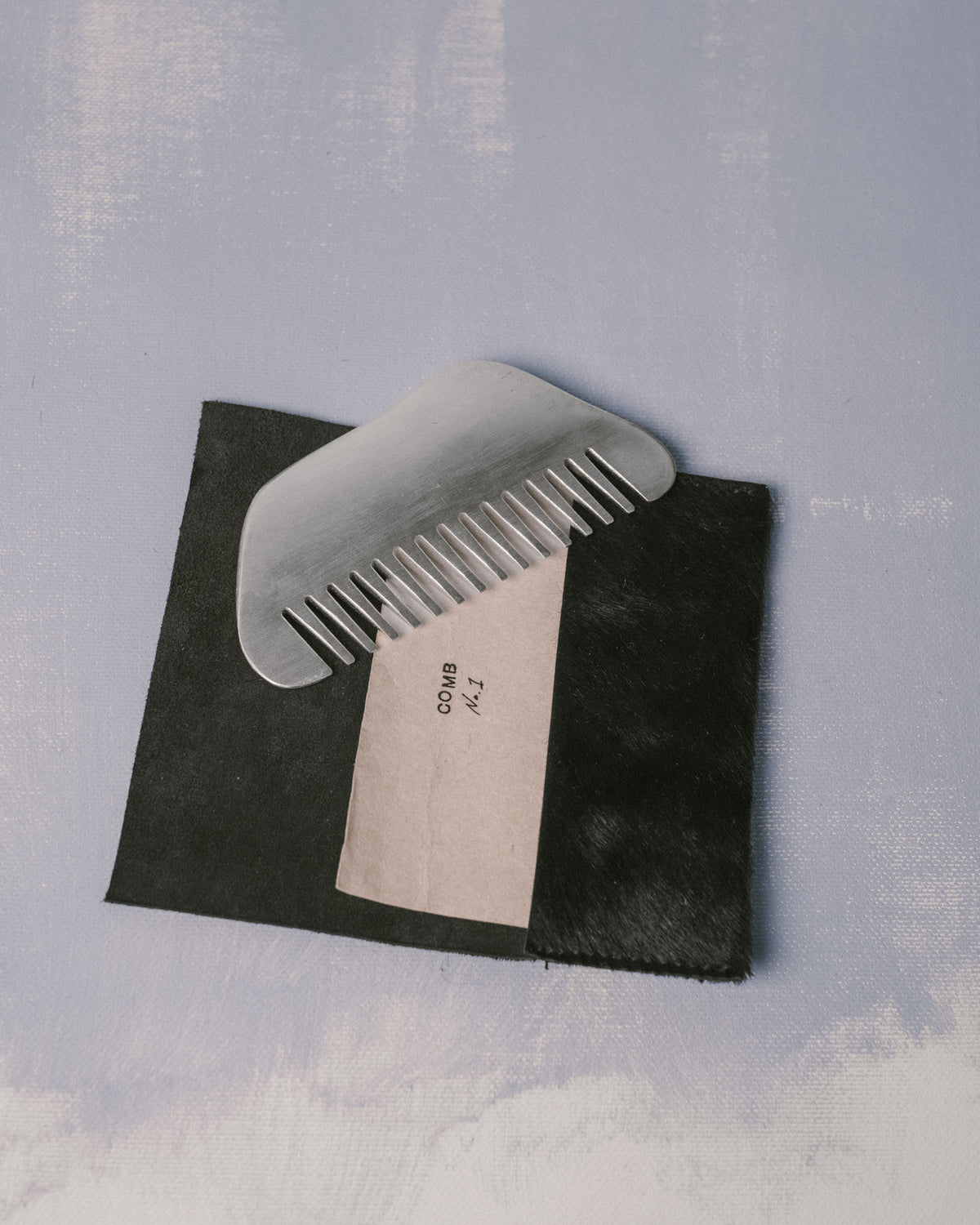 Christian+Jade Comb shown with original packaging, silver-plated metal object