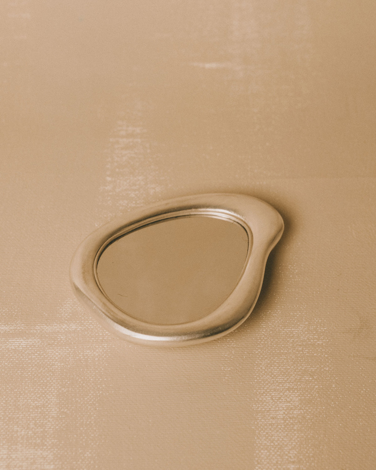 Silver-plated Mirror by Christian+Jade, top-down view showing sculptural pebble form