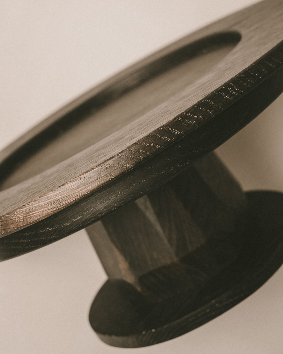 Side view of Christian+Jade Pedestal, carved oxidised oak with sharp geometric base