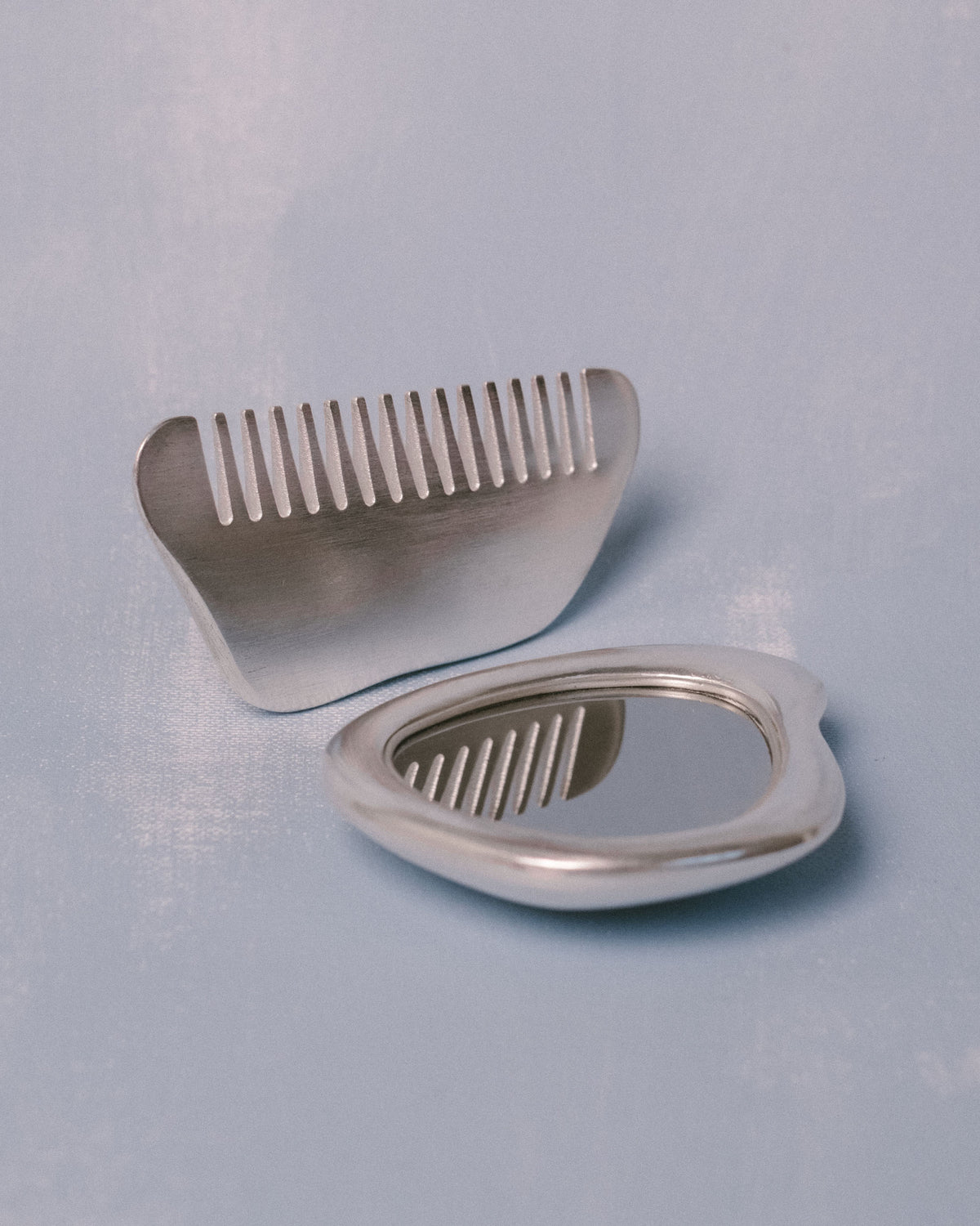Comb detail from Christian+Jade Vanity Set, cast in silver-plated metal with polished finish