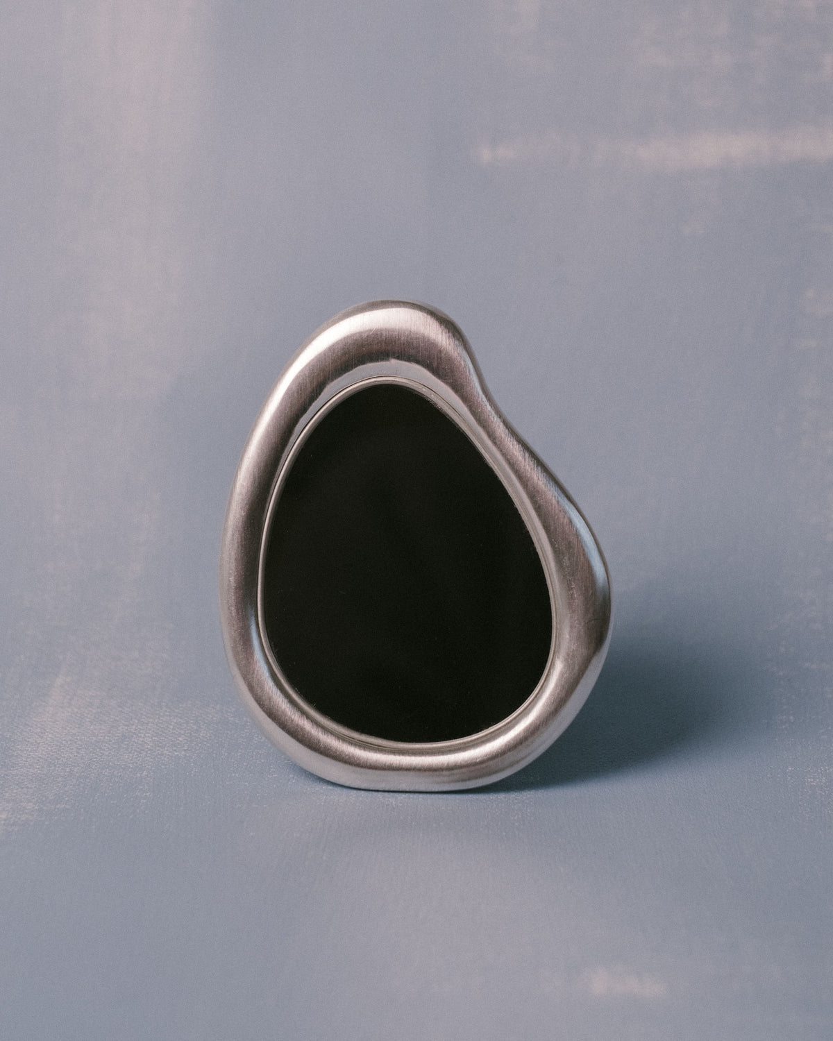 Mirror detail from Christian+Jade Vanity Set, silver-plated metal with sculptural pebble form