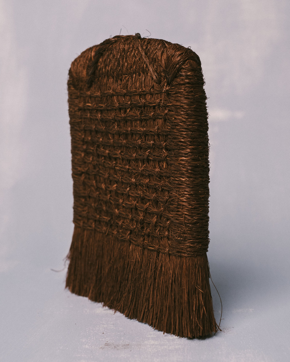 Handwoven palm fiber brush from Taiwan, side profile showing tightly bound weave