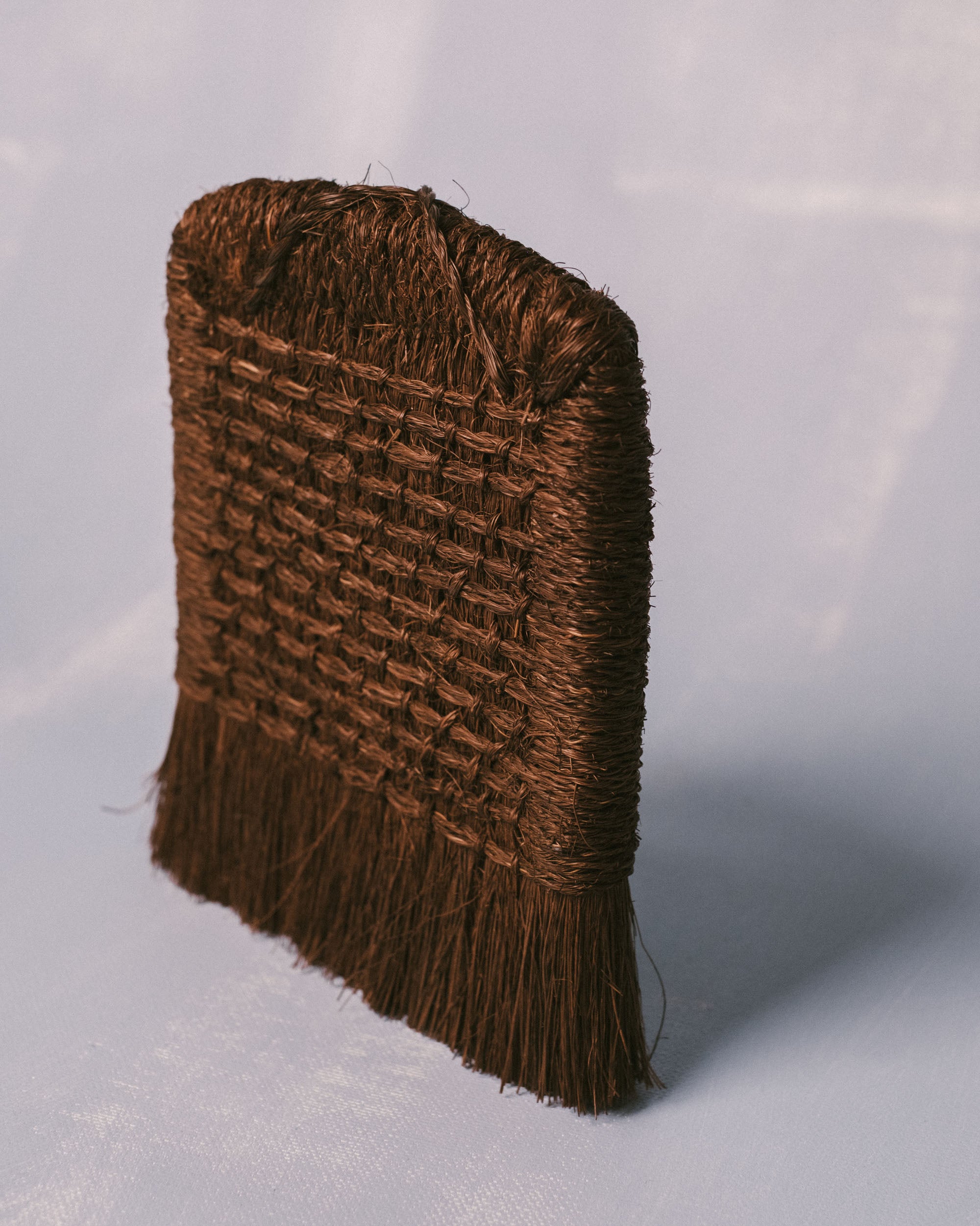 Taiwanese handwoven brush in palm fiber, sculptural utilitarian craft, three-quarter view