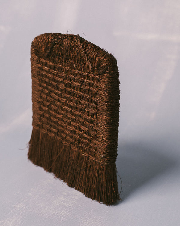 Taiwanese handwoven brush in palm fiber, sculptural utilitarian craft, three-quarter view