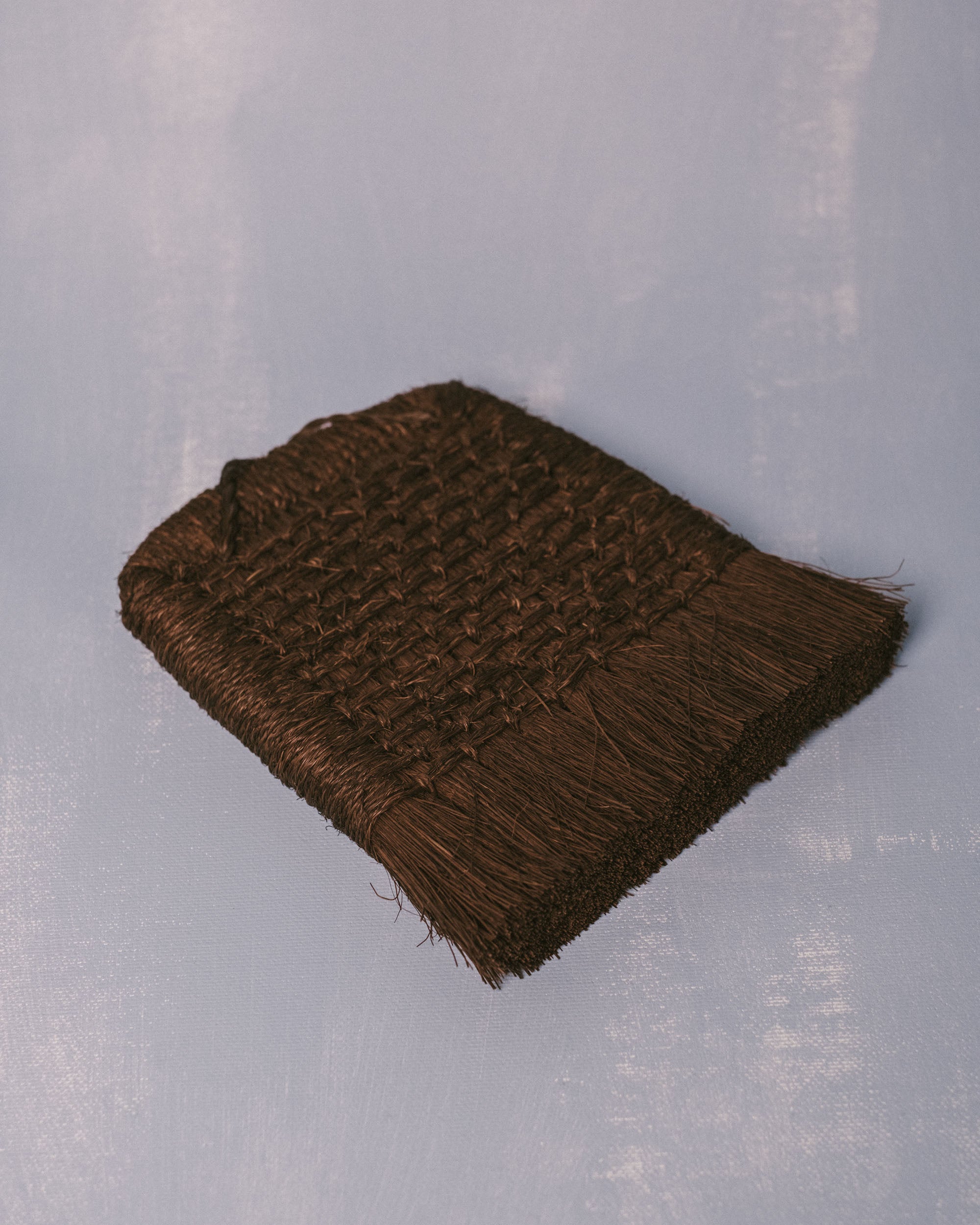 Top-down view of handwoven Taiwanese palm fiber brush, functional sculptural craft