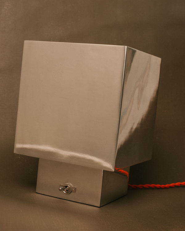 J. Hannah Table Lamp 01 in polished aluminium, angled view highlighting cast base and ribbed glass top