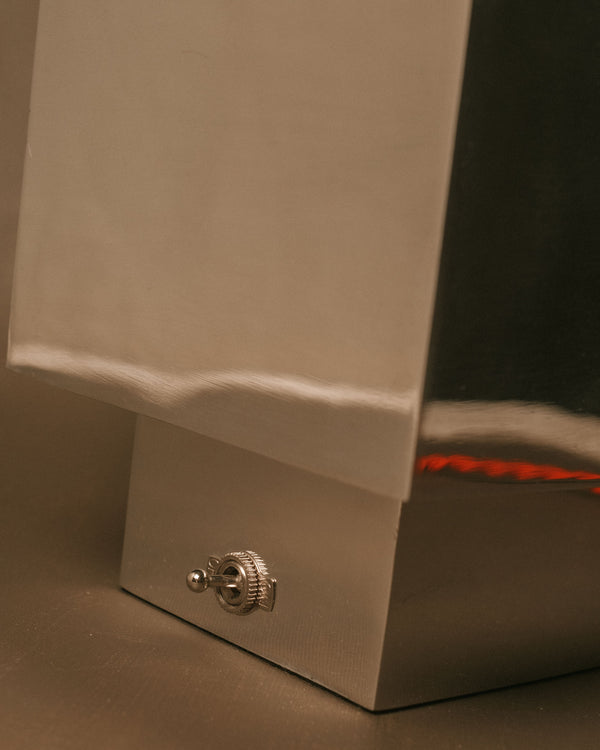 Side profile of J. Hannah Table Lamp 01 showing polished aluminium base and orange cord detail