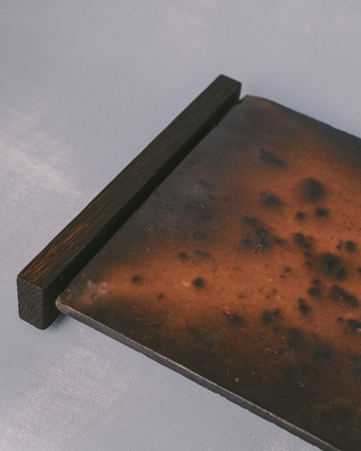 Raku-fired ceramic tile detail on Tray 2, angled view