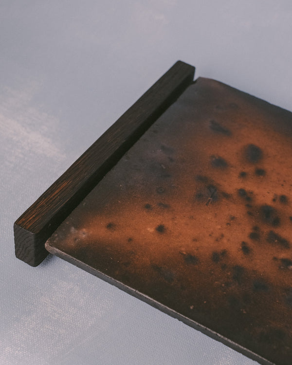 Raku-fired ceramic tile detail on Tray 2, angled view