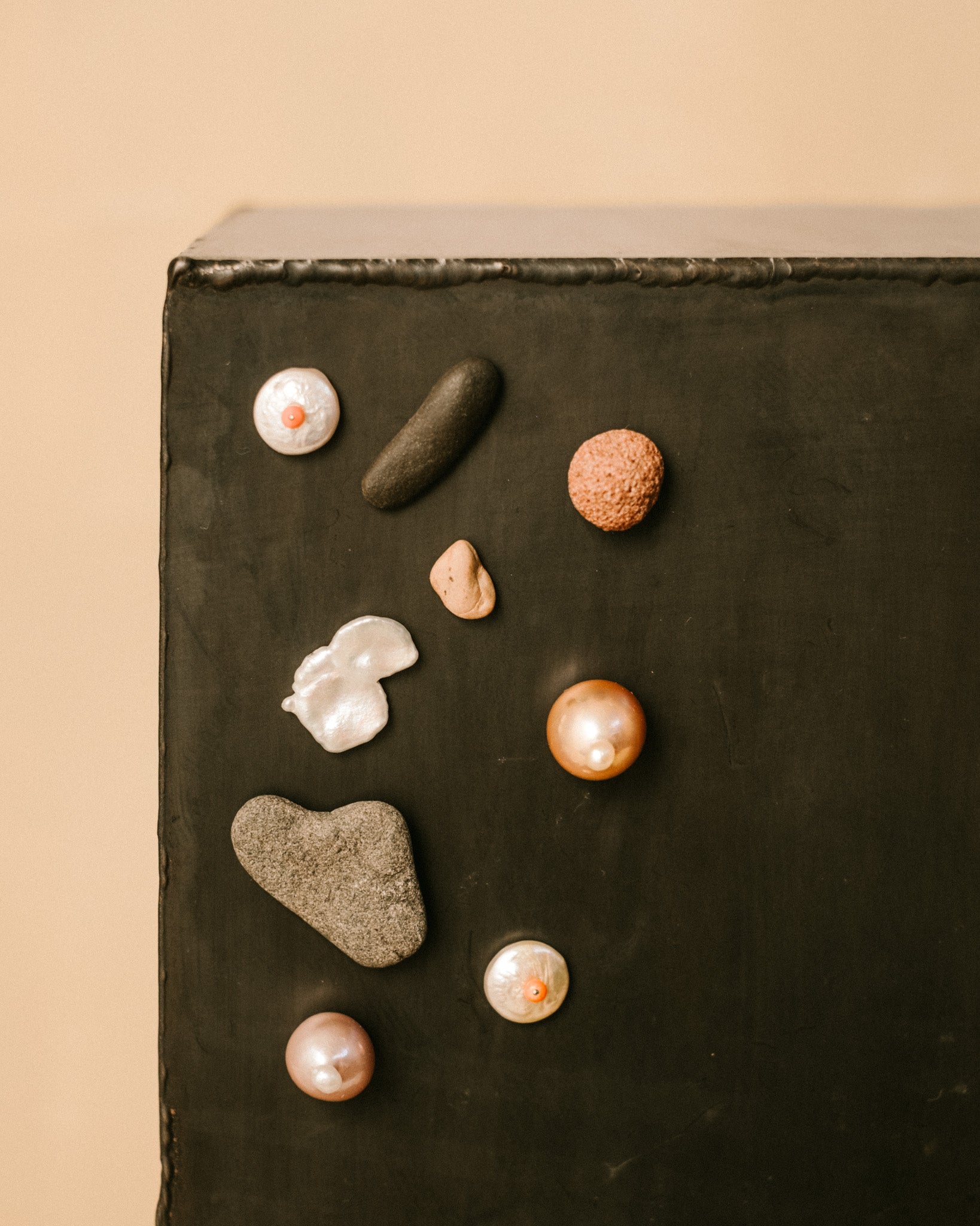 Close-up of Cabinet Jewellery pieces by Lisa Scherebnenko, pebble, pearl, coral, morganite and moonstone on magnetic base