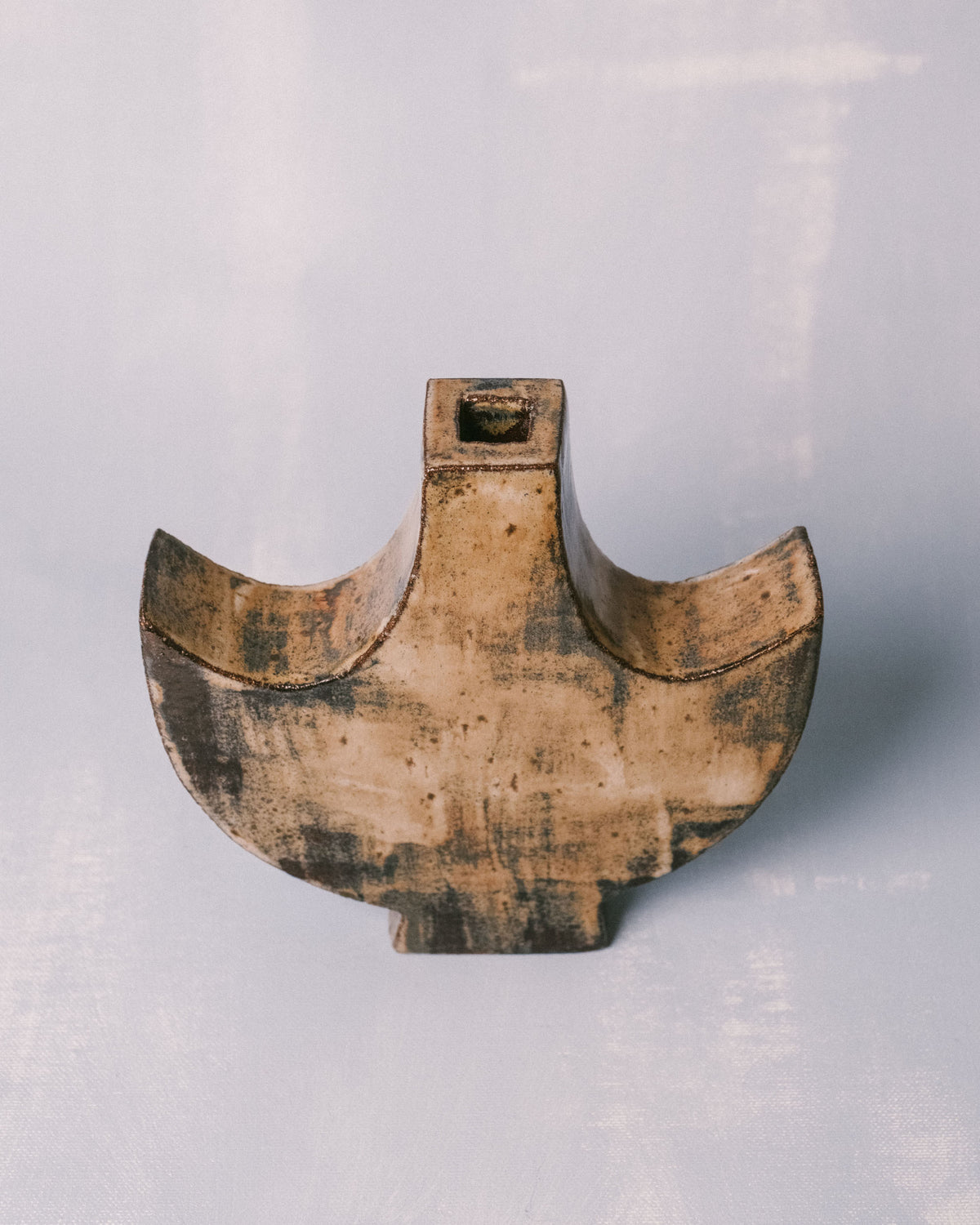 Winged silhouette of Small Angel 1, layered glaze surface, angled view