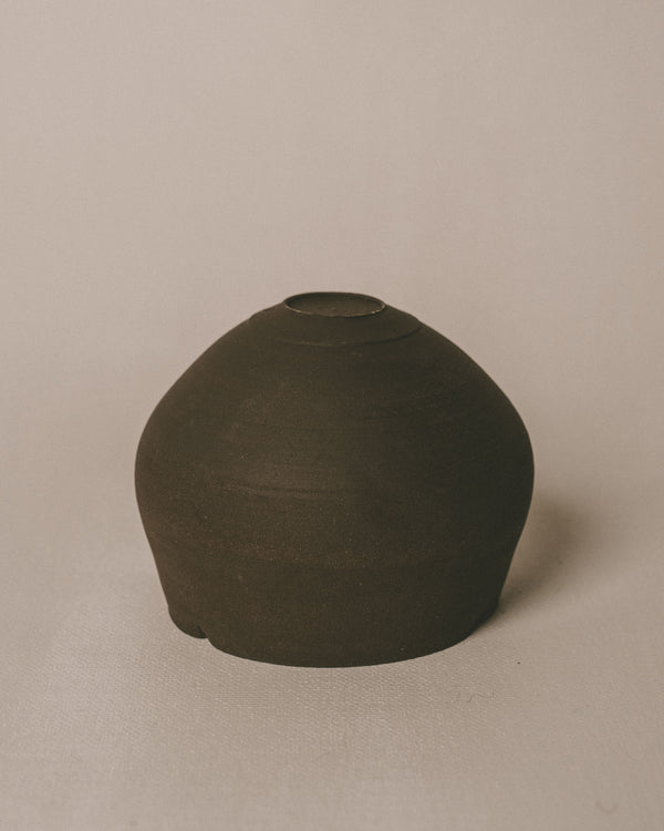 Side profile of Sharlen Nozawa Lotus Cup in Black, unglazed stoneware echoing lotus rhythm