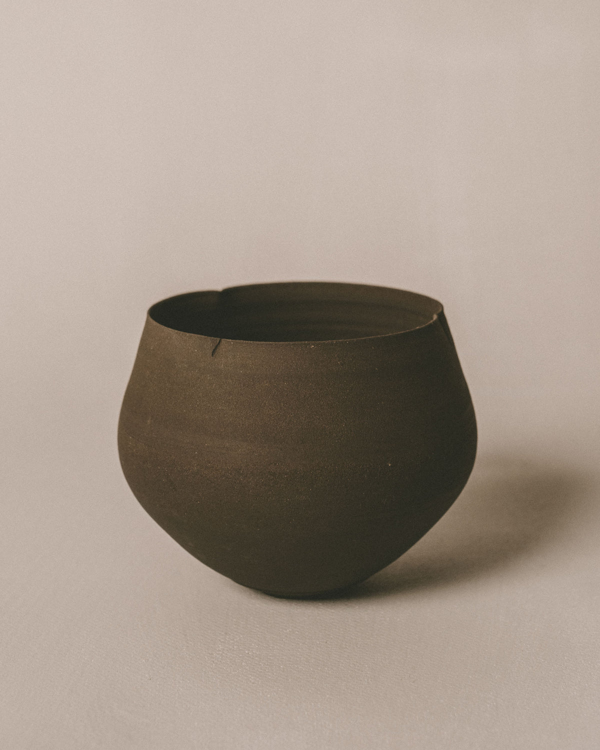 Sharlen Nozawa Lotus Cup in Black, hand-crafted unglazed stoneware inspired by Tang Dynasty lobed wares, front view