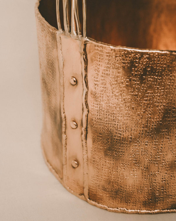 Close-up of rim seam on Basket 4, hand-worked copper texture